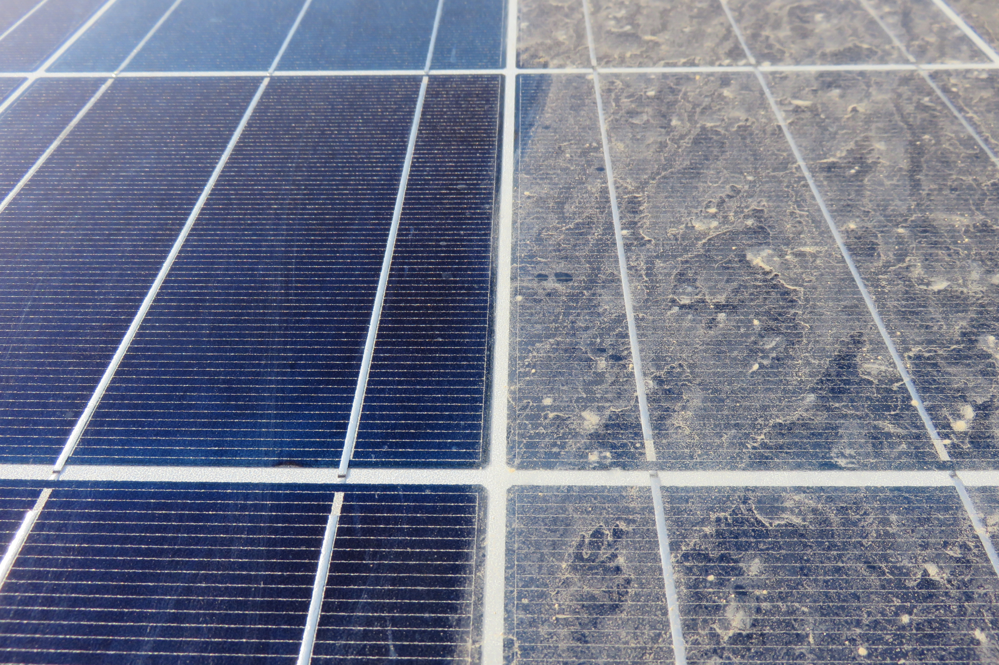 Saubere und verschmutzte Solarpanels im Vergleich, unterschiedliche Farbnuancen sichtbar.